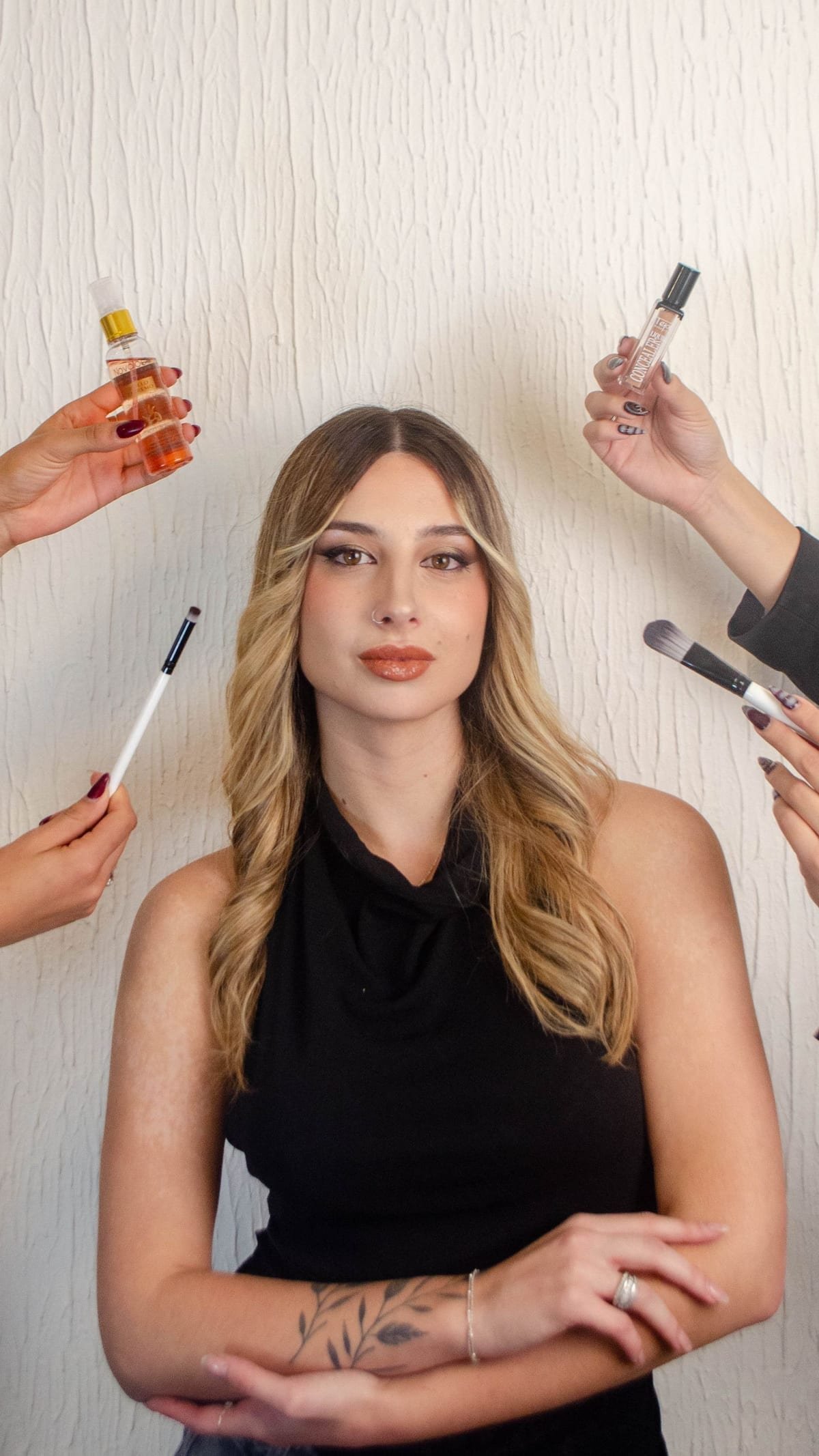 Profissional de maquiagem com os pincéis na mão ao lado da cliente