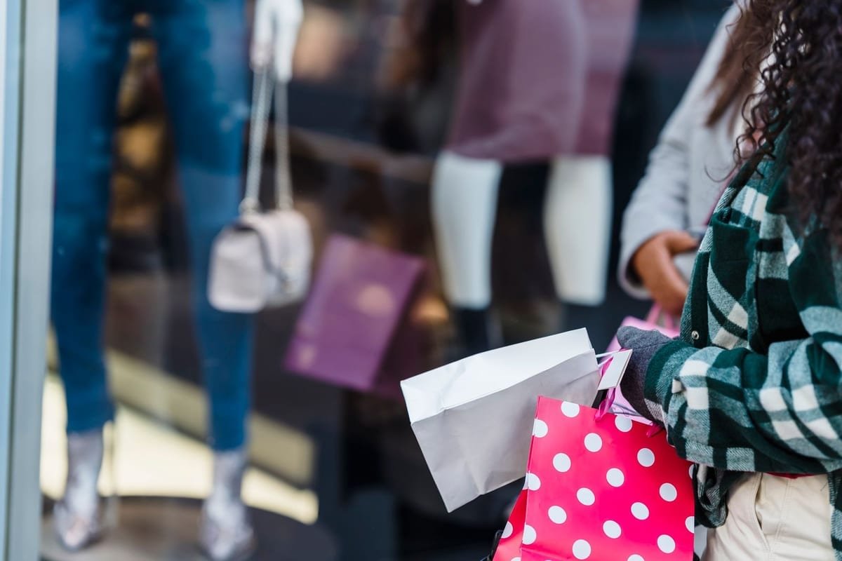 Cliente saindo da loja com as sacolas da compra